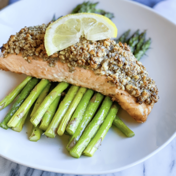 Walnut crusted salmon over asparagus with lemon on top