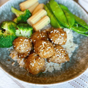 Orange Chicken Meatballs with broccoli, baby corn, snap peas and rice in a bowl