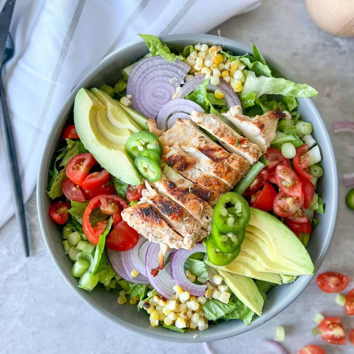 southwest bbq chicken salad in a bowl with veggies and spicy bbq ranch dressing