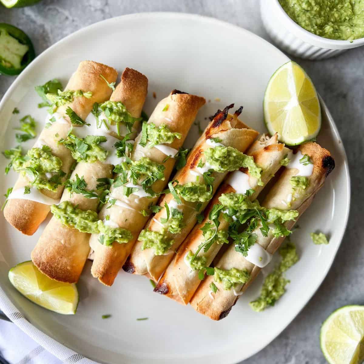 grain free taquitos with sour cream and green sauce drizzled on top