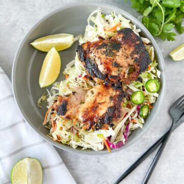Paleo Cilantro Lime Chicken on a plate with slaw and limes