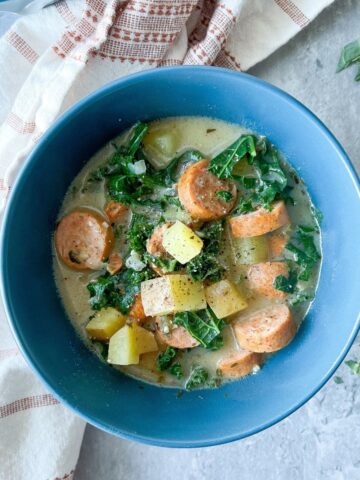 Paleo sausage and kale soup in a blue bowl