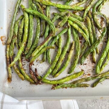 Oven roasted green beans on a pan, up close.